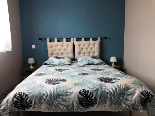 une chambre avec un grand lit avec un mur bleu dans l'établissement À 2 mn du Remblai, de la plage et des commerces, à Les Sables-dʼOlonne