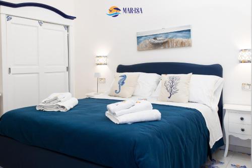 a bedroom with a blue bed with towels on it at MAR-ISA Amalfi Coast in Vietri sul Mare