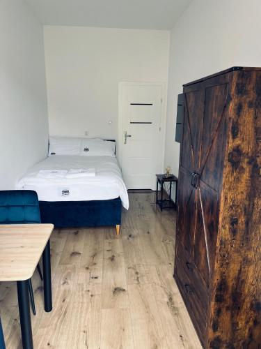 a bedroom with a bed and a large wooden door at Apartamenty przy Muzeum in Brzeziny