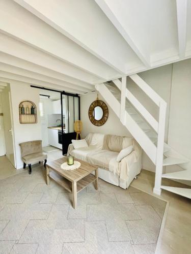 - un salon avec un canapé blanc et des escaliers dans l'établissement Cottage Malenkiy, à Cabourg
