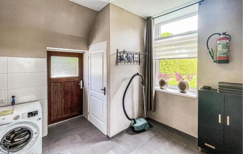 a laundry room with a washing machine and a window at Cozy Home In Harich With Wifi in Harich