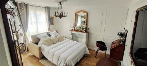 - un salon avec un canapé blanc et un miroir dans l'établissement L'escapade Royale, à Moret-sur-Loing