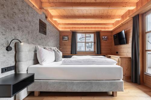 a bedroom with a white bed and a window at Chalet LAUDEGG in Ladis