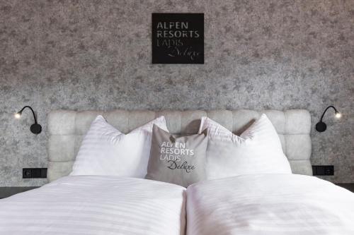 a bedroom with a bed with white sheets and pillows at Chalet LAUDEGG in Ladis