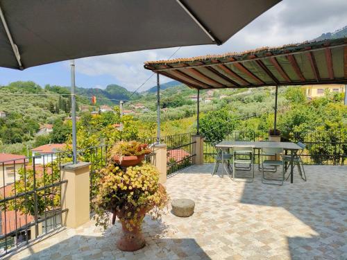 a patio with a table and chairs and an umbrella at casa vacanze La Versilia in Vallecchia