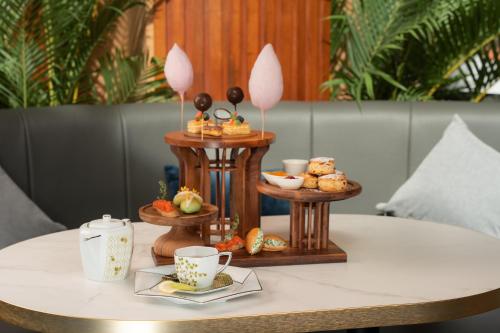 a table with a tray of pastries and cups on it at SUN & MOON, Riverside Hotel in Phnom Penh