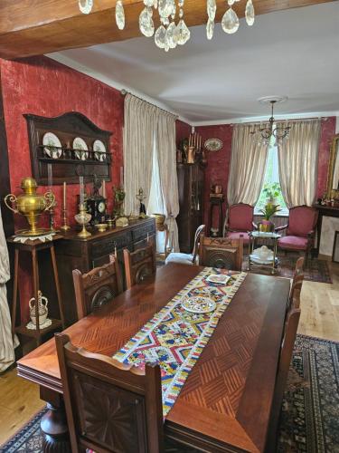 a dining room with a large wooden table and chairs at Chambres hôtes du Pont Lafont in Saint-Denis-lès-Martel