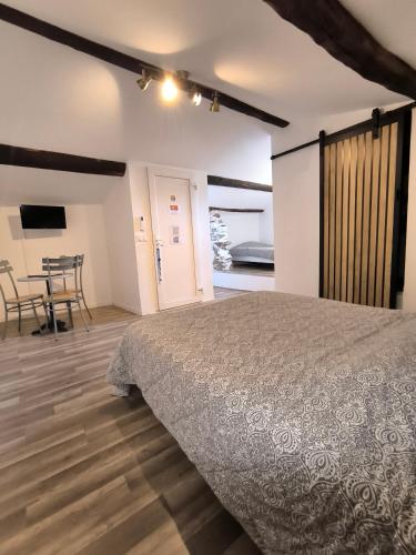 une chambre avec un lit, une table et des chaises dans l'établissement HOULALA - Relais d'étape - Chambres d'hôtes, à Pont-Évêque