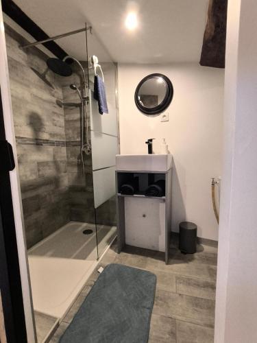 une salle de bain avec douche et lavabo dans l'établissement HOULALA - Relais d'étape - Chambres d'hôtes, à Pont-Évêque