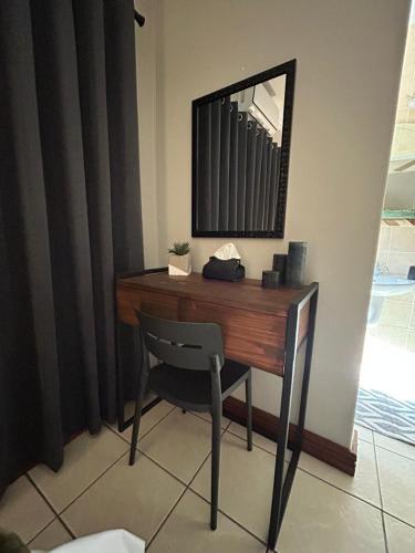 a desk with a chair and a mirror on a wall at Fish Eagle Bay 28, Warmbaths in Bela-Bela
