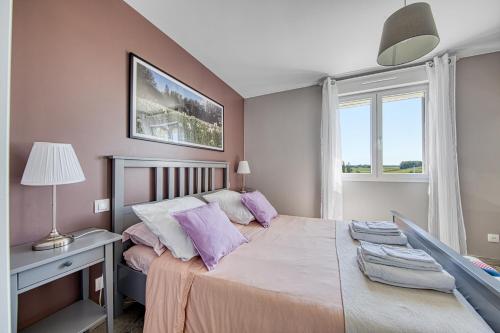 ein Schlafzimmer mit einem großen Bett mit lila Kissen in der Unterkunft Au cœur des vignes in Montagne