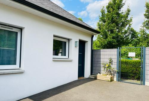 une maison blanche avec une porte bleue et une clôture dans l'établissement La maison de Lilette proche Argelès Gazost, à Ayzac-Ost