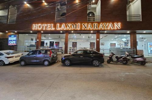 un gruppo di auto parcheggiate davanti a un hotelianeiane karavanani di Hotel Laxmi Narayan a Rishikesh