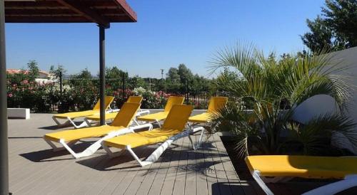 una fila de sillas amarillas sentadas en un patio en Studio Dolce Vita Aix en Provence, en Aix-en-Provence