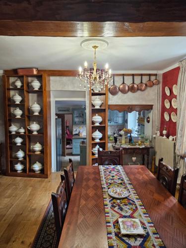 a dining room with a table and a kitchen at Chambres hôtes du Pont Lafont in Saint-Denis-lès-Martel