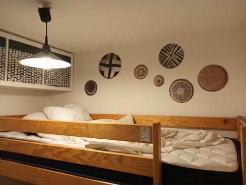 une chambre avec deux lits superposés avec des plaques au mur dans l'établissement Un petit coin de Paradis, à Frontignan