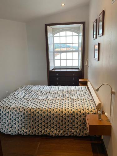 a bedroom with a bed and a window in it at Apartamento Memória in Angra do Heroísmo