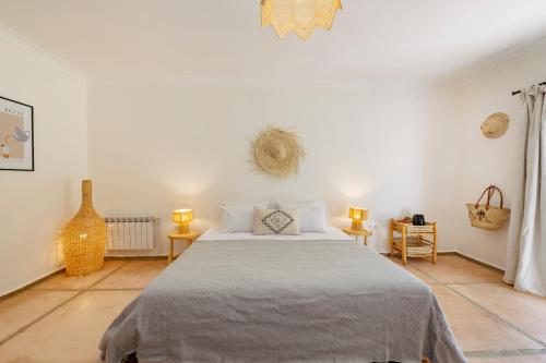 a bedroom with a large bed in a white room at Le mas de l'Ourika, maison d'hôtes in Aït Zat