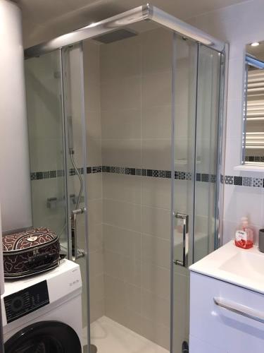 une douche avec une porte vitrée dans une salle de bain dans l'établissement Un petit coin de Paradis, à Frontignan