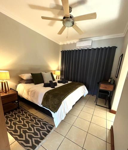 a bedroom with a bed and a ceiling fan at Fish Eagle Bay 28, Warmbaths in Bela-Bela