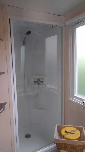 une salle de bain avec une douche avec une porte vitrée dans l'établissement Camping 3 étoiles - Parc aquatique - cca0gdc, à Saint-Maime