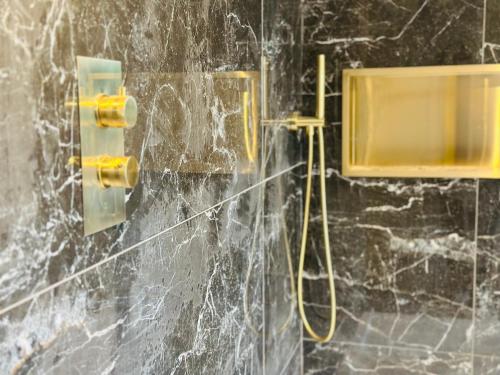 a bathroom with a shower with a hose on a wall at Red Roofs - 5BR Luxury - Large Gardens - EV Point - Near Edinburgh in Newtongrange
