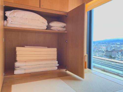 a room with a closet with towels and a window at Tokyu Vacations Fujisan Mishima in Mishima