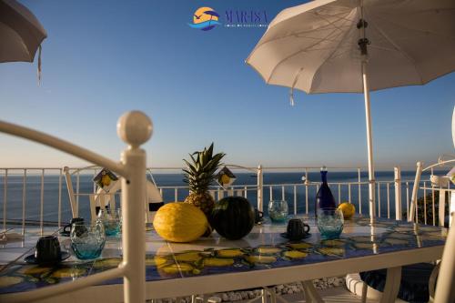 a table with fruits and bottles of wine and an umbrella at MAR-ISA Amalfi Coast in Vietri sul Mare