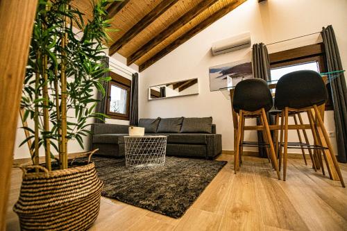 a living room with a couch and two chairs at Apartamentos O Grilo in Doade