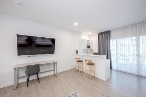 a white kitchen with a desk and two chairs at GRAND PA Hotel&Resort Lamphun Chiang Mai in Lamphun