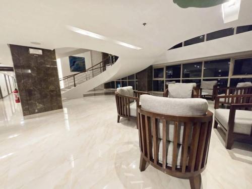 a living room with chairs and a staircase at City Serenity Escape in Manila
