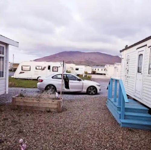 una macchina bianca parcheggiata in un parcheggio con tende di Beautiful Mobile Home a Tralee