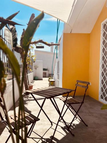 a table and chairs on a balcony with a plant at Dream Holiday in Marina di Lizzano
