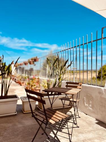 a patio with two chairs and a table and a fence at Dream Holiday in Marina di Lizzano