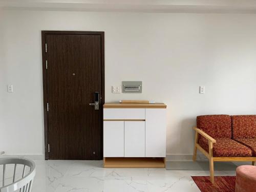 a room with a door and a couch and a chair at Charm Apartment in Dĩ An