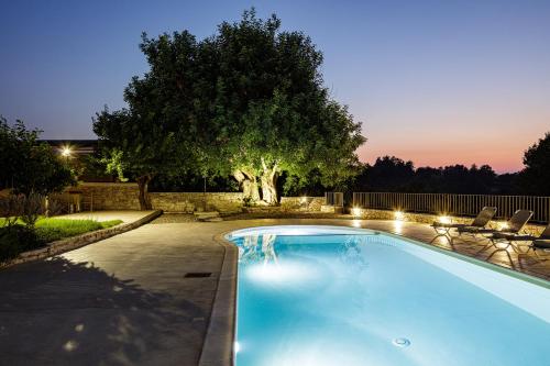 a swimming pool in a yard with a tree at Mithonies Villa, with Private Pool & BBQ, By ThinkVilla in Margarítai