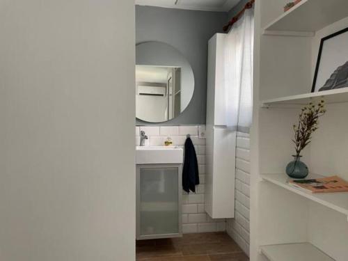 a white bathroom with a sink and a mirror at Apartamento con jardín cerca playa y a 15 min de Plaza Catalunya en tren in Sant Adria de Besos