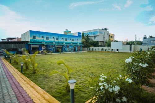 a large grass field in front of a building at Hotel Pergola - Mysore in Chāmundi