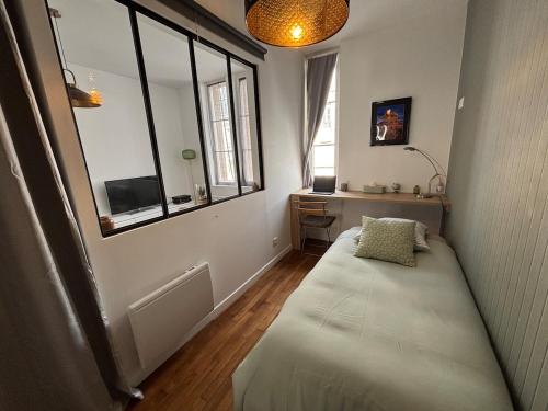 une chambre avec un banc dans une chambre avec une fenêtre dans l'établissement Le Saint André Hyper centre ville, à Saint-Quentin