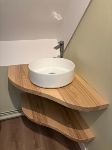 baño con lavabo blanco en una estantería de madera en Les Tamaris Vue Mer, en Roscoff