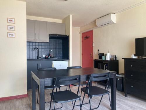 une cuisine avec une table et des chaises dans une pièce dans l'établissement Appartement Marius, au Grau-du-Roi