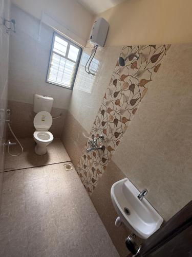a bathroom with a toilet and a sink at Hotel Wow Inn - Dhanori-Lohegaon Rd, Parande Nagar, Dhanori, Pune in Pune