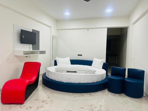 a bedroom with a bed and a red chair at Hotel Wow Inn - Dhanori-Lohegaon Rd, Parande Nagar, Dhanori, Pune in Pune