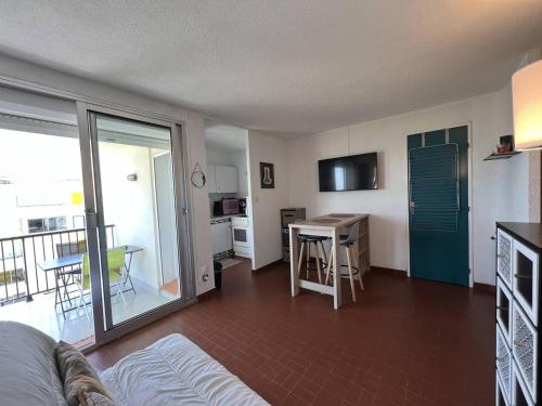un salon avec un canapé et une cuisine avec une table dans l'établissement Appartement T2 4 pers, bord de mer, Port Barcarès - FR-1-81-639, au Barcarès