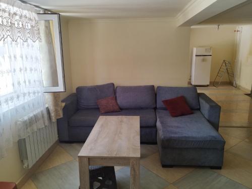 a living room with a blue couch and a table at Armenia Home in Pʼarakʼar