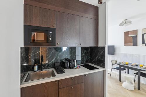 - une cuisine avec des placards en bois et un four micro-ondes dans l'établissement Appartement Guersant Pereire, à Paris