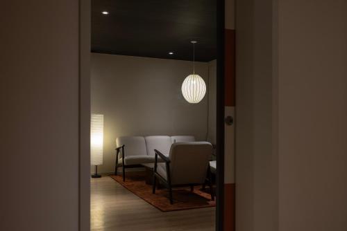 a dining room with a table and chairs and a light at Koum Ryokan Hotel Gijang by Aank in Busan