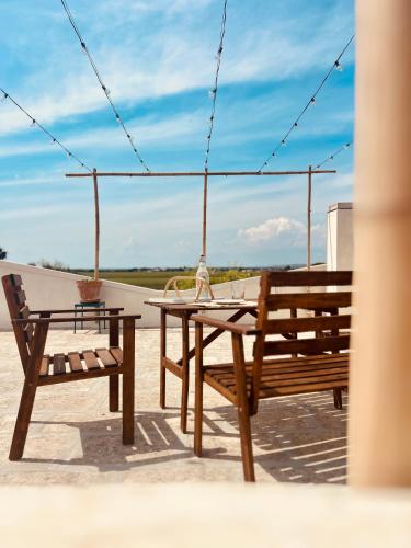 a table and two benches sitting on top of a roof at Dream Holiday in Marina di Lizzano