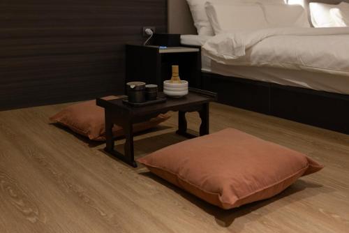 a room with a bed and a table with a bed sidx sidx sidx at Koum Ryokan Hotel Gijang by Aank in Busan