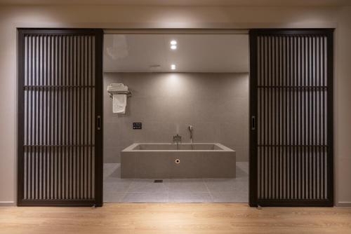 a bathroom with a bath tub in a room at Koum Ryokan Hotel Gijang by Aank in Busan